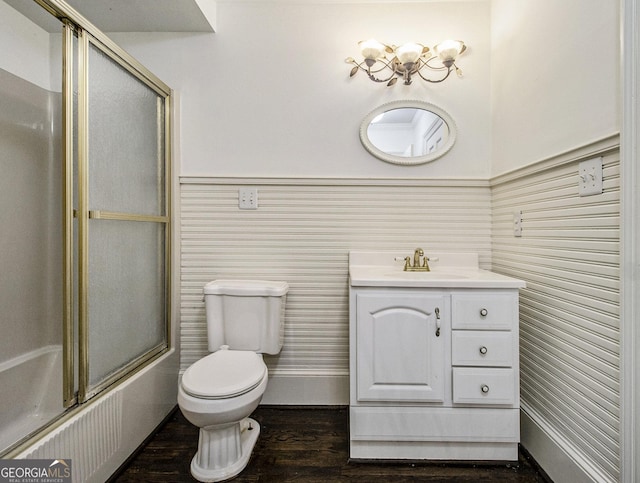 full bathroom featuring combined bath / shower with glass door, wood-type flooring, vanity, and toilet