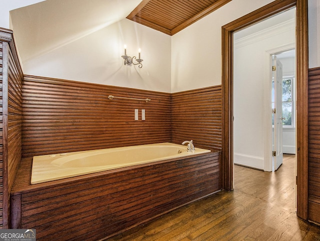 bathroom with wood-type flooring, wood ceiling, crown molding, and a tub