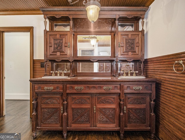 bar featuring wood walls, crown molding, wooden ceiling, and sink