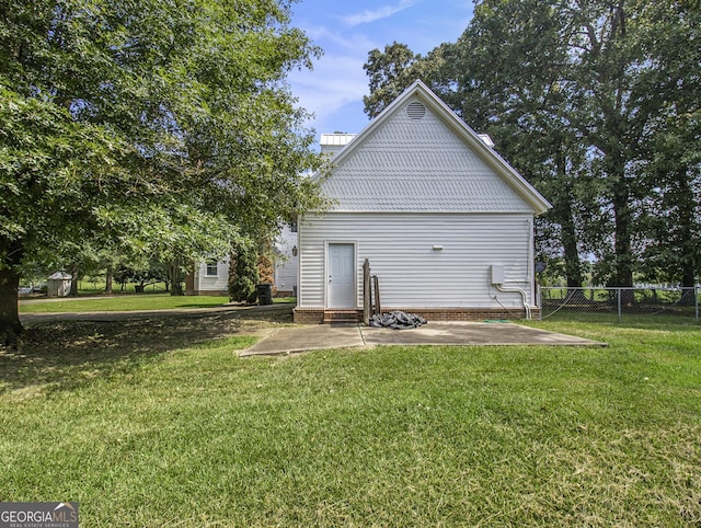 back of house with a patio area and a yard