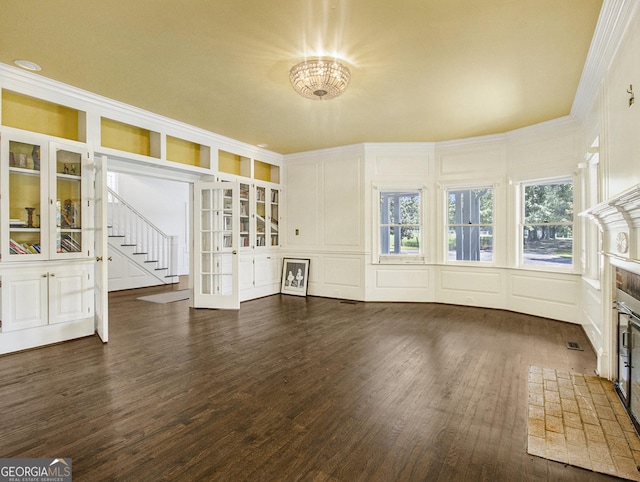 unfurnished living room with french doors, dark hardwood / wood-style floors, and a notable chandelier