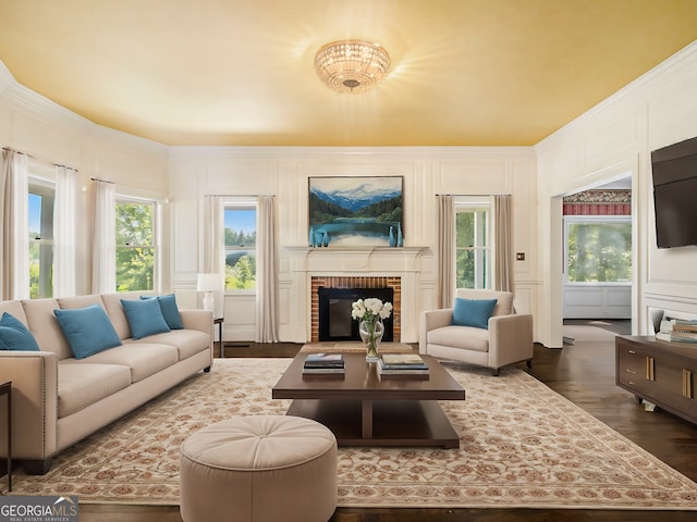 living room featuring a chandelier, dark hardwood / wood-style flooring, and a brick fireplace