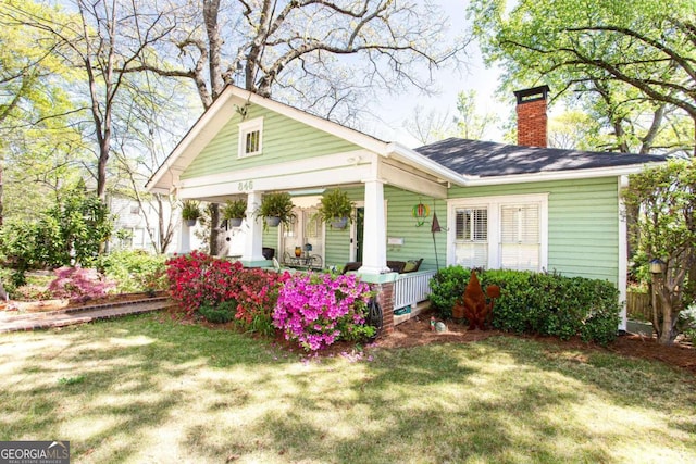 back of house with a lawn and a porch