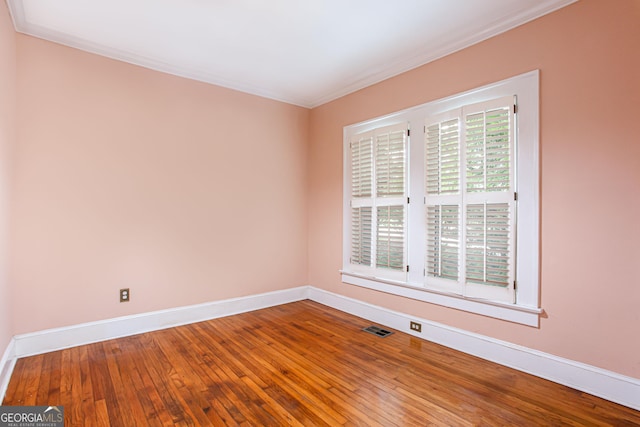 empty room featuring crown molding and hardwood / wood-style floors