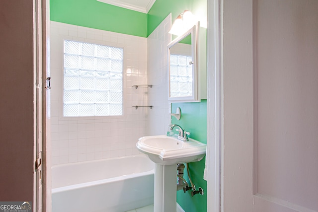 bathroom with a tub to relax in, sink, and ornamental molding