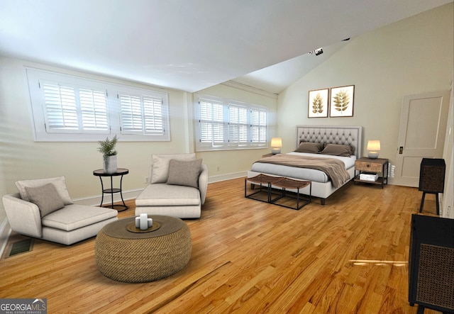 bedroom featuring lofted ceiling and light wood-type flooring