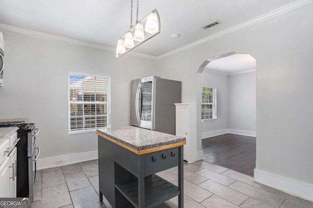 kitchen featuring white cabinetry, appliances with stainless steel finishes, crown molding, light tile patterned flooring, and a center island