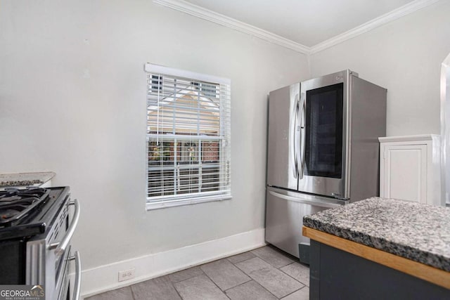 kitchen with appliances with stainless steel finishes, ornamental molding, and light tile patterned floors