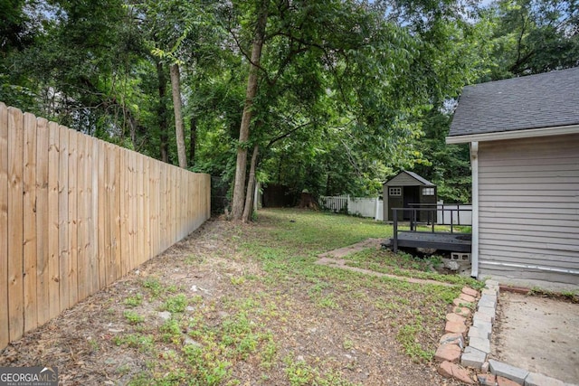 view of yard featuring a storage shed and a wooden deck