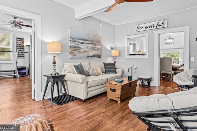 living room with hardwood / wood-style flooring, ceiling fan, and beamed ceiling