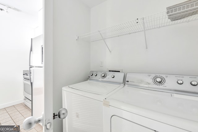 laundry area featuring washing machine and dryer and light tile patterned floors