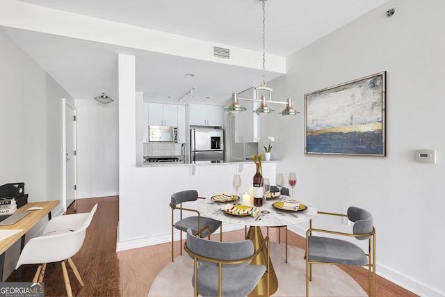 dining area with sink and wood-type flooring