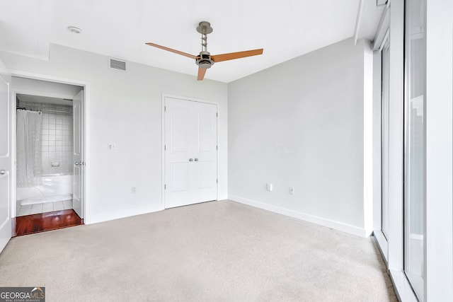 unfurnished bedroom with ensuite bathroom, ceiling fan, and carpet floors