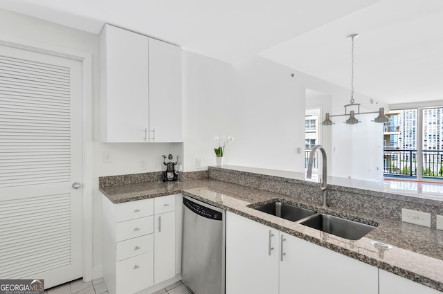 kitchen with sink, dishwasher, dark stone counters, and white cabinetry