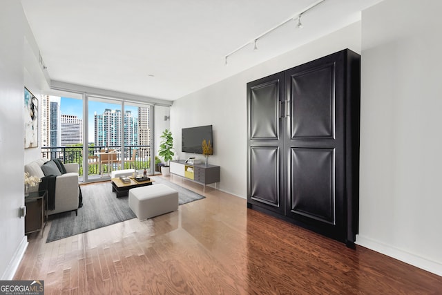 living room featuring track lighting, floor to ceiling windows, and hardwood / wood-style floors