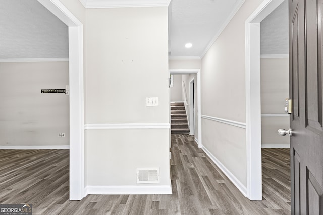 corridor featuring a textured ceiling, ornamental molding, and hardwood / wood-style flooring