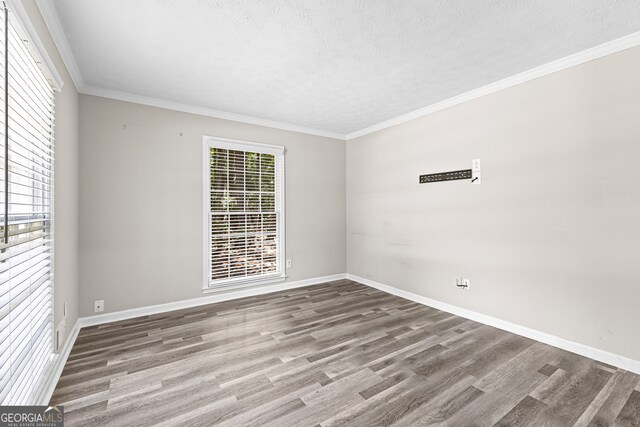 unfurnished room featuring hardwood / wood-style flooring, a textured ceiling, and ornamental molding