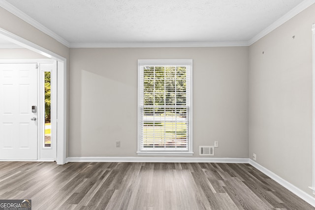 foyer entrance with a textured ceiling, ornamental molding, and hardwood / wood-style flooring