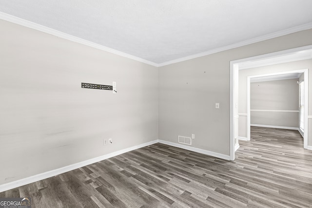 empty room with hardwood / wood-style flooring and ornamental molding