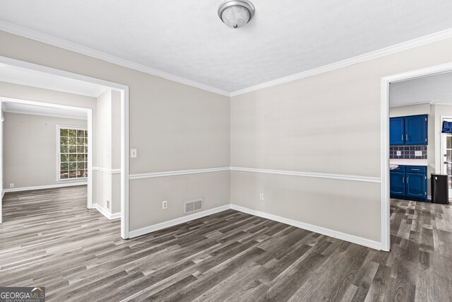 spare room with dark wood-type flooring and ornamental molding