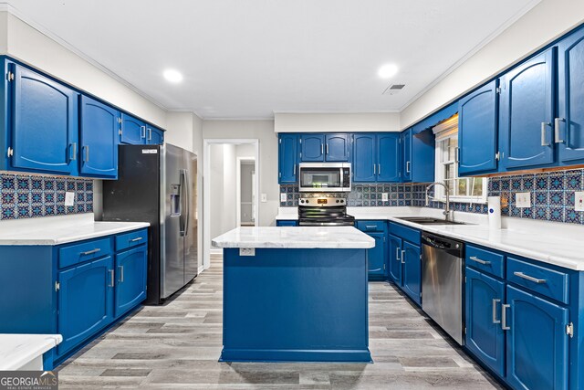 kitchen with appliances with stainless steel finishes, light hardwood / wood-style flooring, blue cabinetry, and decorative backsplash