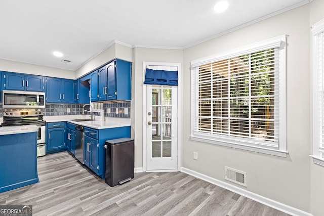 kitchen with plenty of natural light, appliances with stainless steel finishes, and light hardwood / wood-style floors