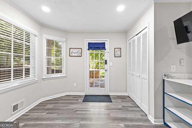 doorway featuring crown molding and hardwood / wood-style flooring