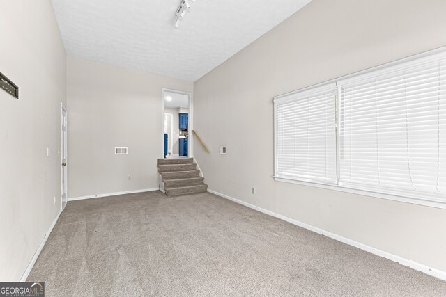 unfurnished room featuring carpet floors and track lighting