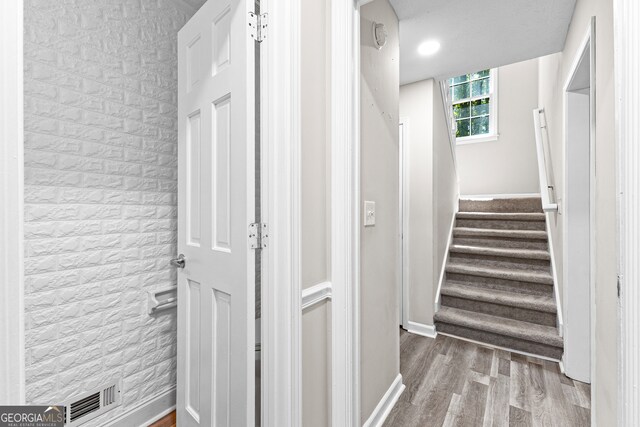 interior space with brick wall and wood-type flooring