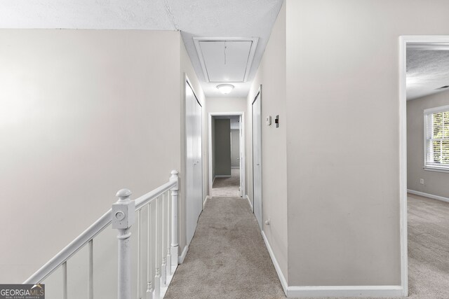 corridor featuring carpet flooring and a textured ceiling