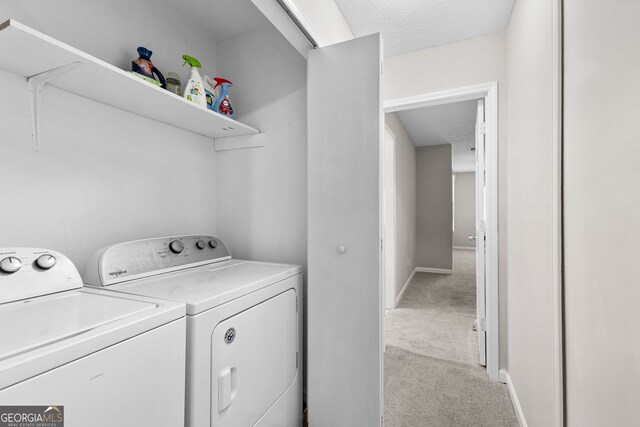 washroom with a textured ceiling, separate washer and dryer, and light carpet