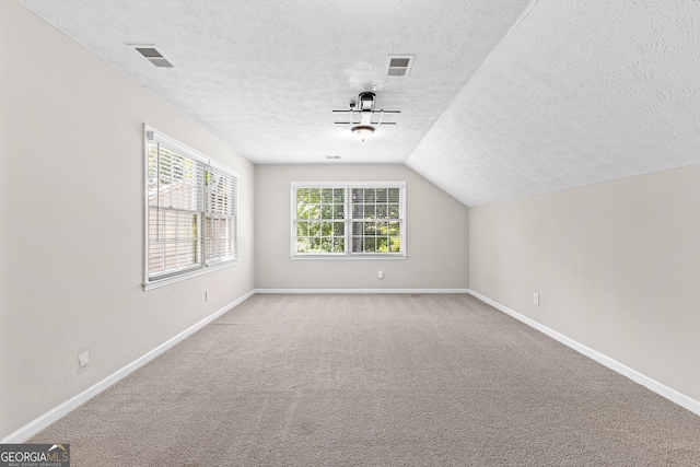 bonus room featuring carpet flooring, a textured ceiling, and lofted ceiling