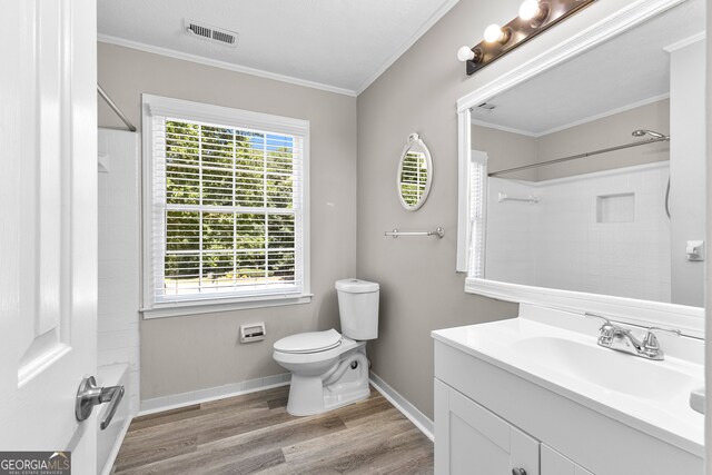 full bathroom featuring toilet, wood-type flooring, plenty of natural light, and vanity