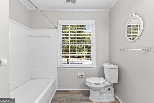 bathroom featuring crown molding, a textured ceiling, wood-type flooring, toilet, and washtub / shower combination