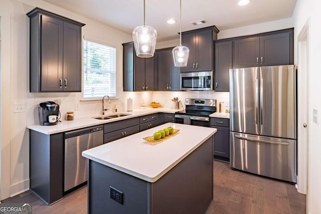 kitchen with decorative backsplash, appliances with stainless steel finishes, sink, dark wood-type flooring, and a kitchen island