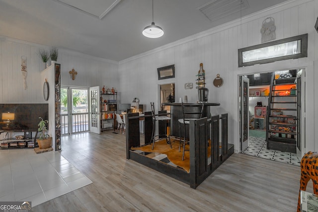 interior space featuring visible vents, crown molding, a dry bar, and wood finished floors