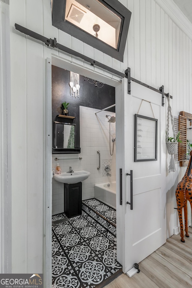 full bathroom with tile walls, wood finished floors, and shower / bathing tub combination