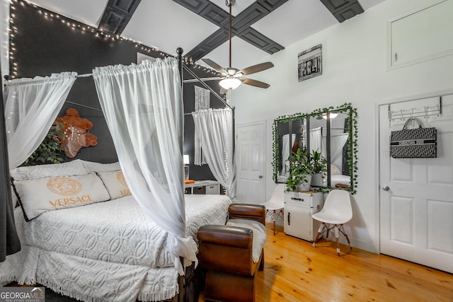 bedroom featuring wood finished floors, a towering ceiling, and baseboards