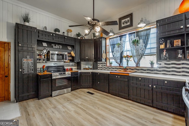 kitchen with light wood finished floors, open shelves, stainless steel appliances, light countertops, and ornamental molding