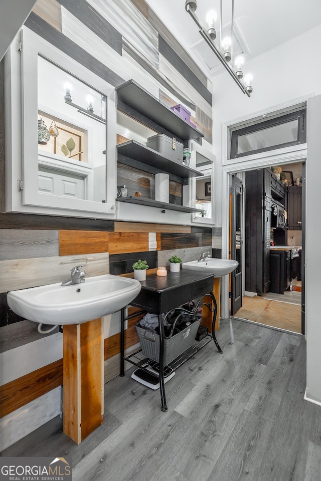 bathroom with a chandelier and wood finished floors