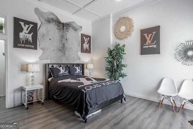 bedroom with baseboards, ornamental molding, and wood finished floors