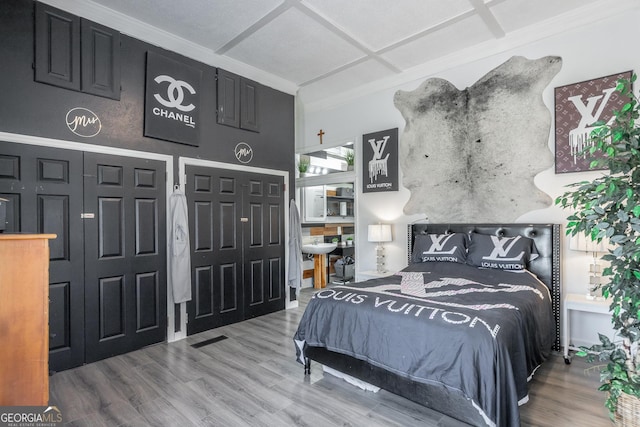 bedroom featuring visible vents and wood finished floors