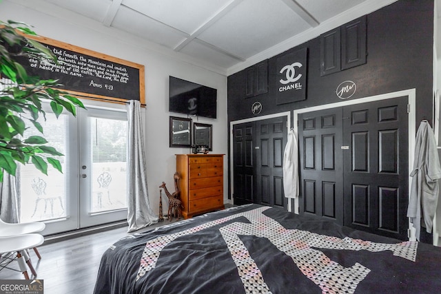 bedroom featuring coffered ceiling, wood finished floors, multiple closets, access to outside, and french doors