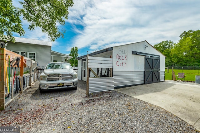 view of outdoor structure with an outbuilding and fence