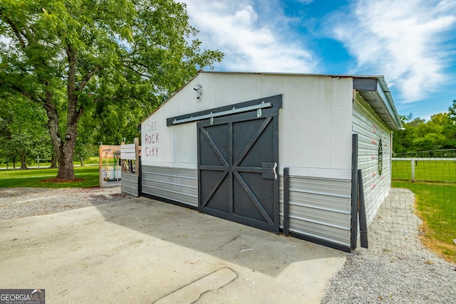 view of outdoor structure with an outbuilding and fence