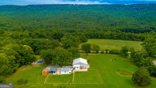 drone / aerial view featuring a rural view and a view of trees