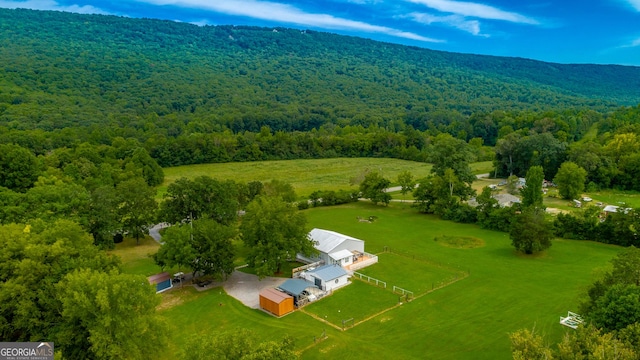 drone / aerial view featuring a rural view and a wooded view