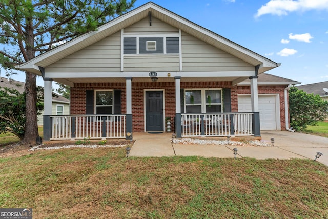 view of front of house featuring covered porch, a front yard, and a garage