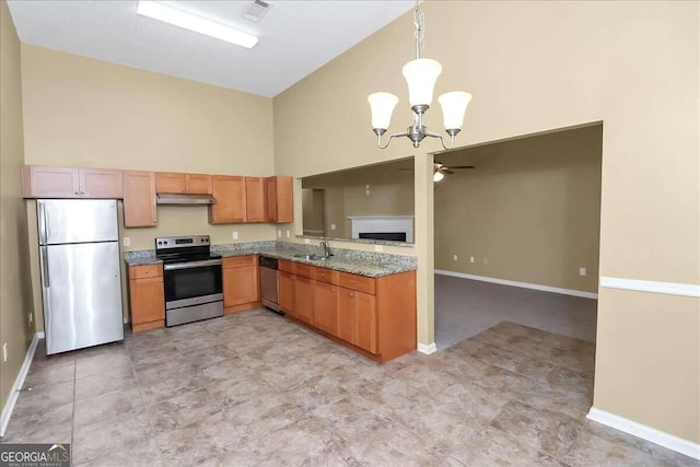 kitchen with ceiling fan with notable chandelier, appliances with stainless steel finishes, high vaulted ceiling, light tile patterned flooring, and decorative light fixtures