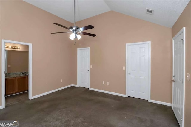 unfurnished bedroom featuring dark carpet, high vaulted ceiling, ceiling fan, and ensuite bathroom